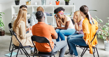 group of people consoling the depress woman