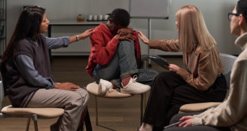 two woman consoling the man